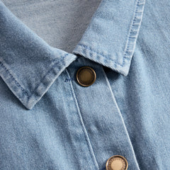 Light blue denim flared long sleeve jumpsuit with wide-leg pants for women, featuring a stylish and relaxed fit.
