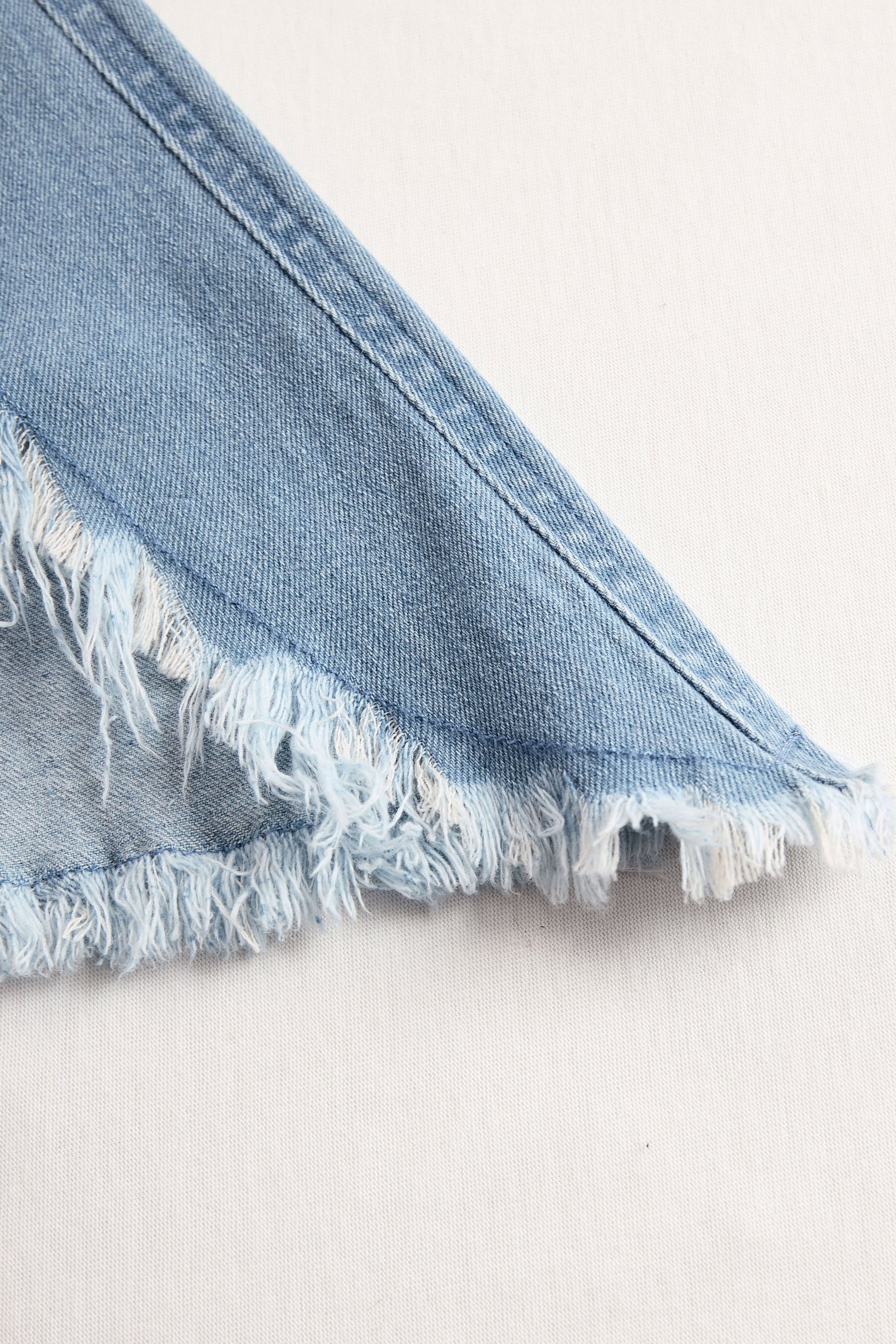 Light blue denim sleeveless raw edge wide-leg jumpsuit for women, stylish and casual, featuring a relaxed fit and raw hem details.