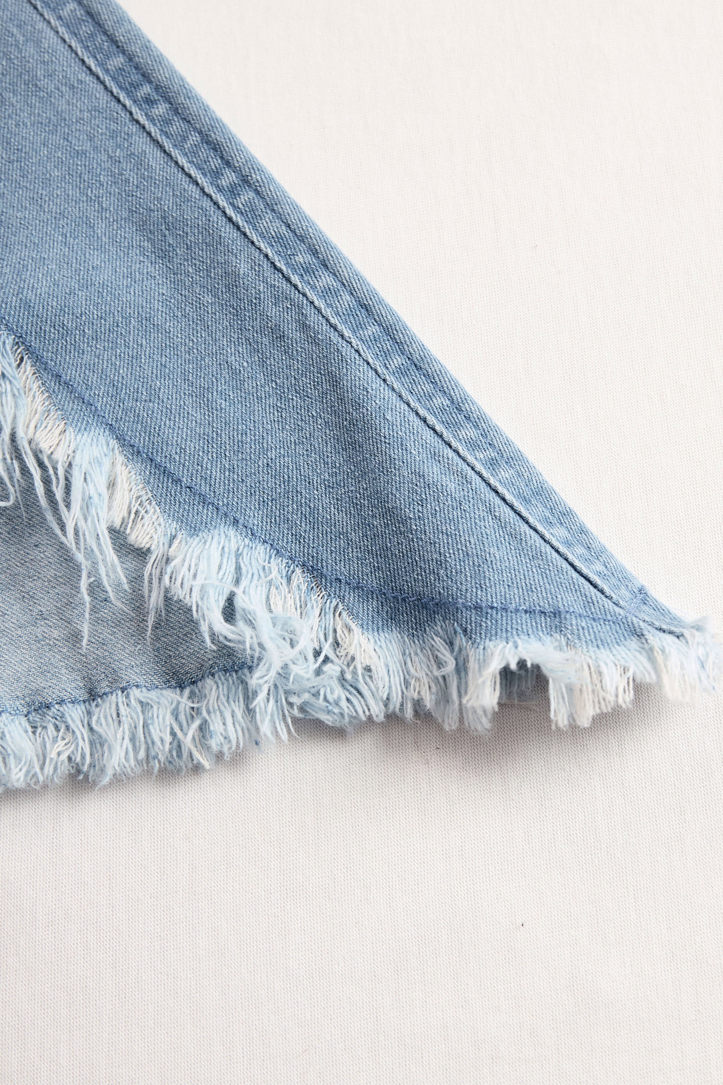Light blue denim sleeveless raw edge wide-leg jumpsuit for women, stylish and casual, featuring a relaxed fit and raw hem details.
