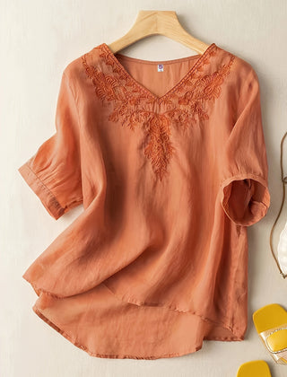 Light blue V-neck linen summer blouse for women, flowing and casual, displayed on a hanger with a relaxed fit.