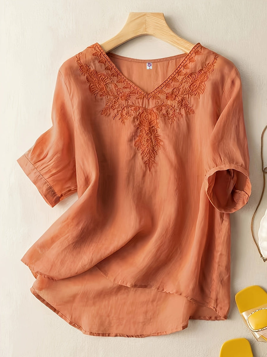 Light blue V-neck linen summer blouse for women, flowing and casual, displayed on a hanger with a relaxed fit.