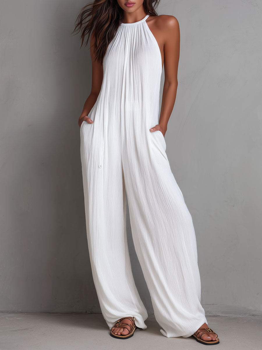 White pleated halter neck wide-leg resort jumpsuit for women, featuring stylish pants with a relaxed fit and elegant design.
