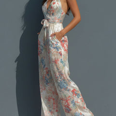 White floral satin halter neck jumpsuit for women with wrap front and wide-leg pants, stylish and elegant design.