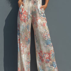 White floral satin halter neck jumpsuit with wrap front and wide-leg pants for women, stylish and elegant.