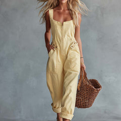 Light yellow denim jumpsuit with square neckline and zip front, women's pants by My Store, shown hanging on a hanger.
