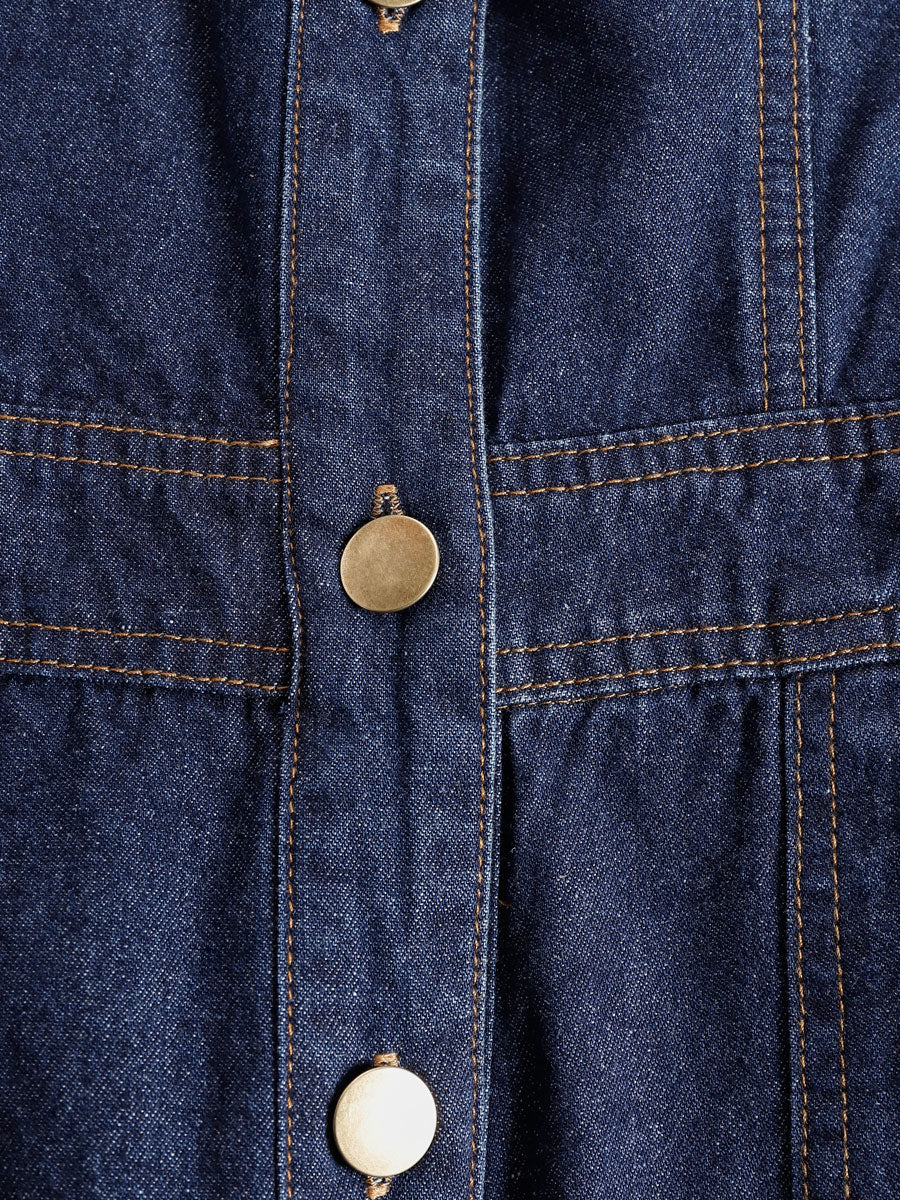 Dark blue denim sleeveless balloon jumpsuit with multiple pockets, designed for women, featuring a relaxed fit and stylish silhouette.