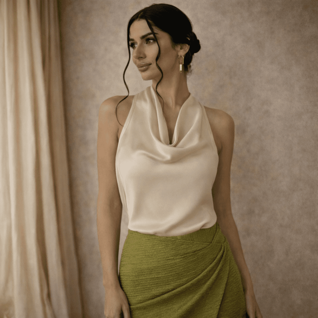 Cream satin cowl-neck sleeveless top for women by Tammy Bradley, shown with draped fabric and elegant cowl neckline.