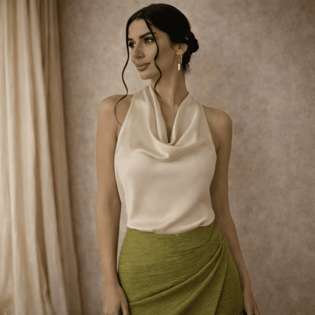 Cream satin cowl-neck sleeveless top for women by Tammy Bradley, shown with draped fabric and elegant cowl neckline.