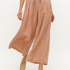 Loose tapered linen trousers for women, stylish pull-on pants in neutral fabric, perfect for casual or elegant wear.