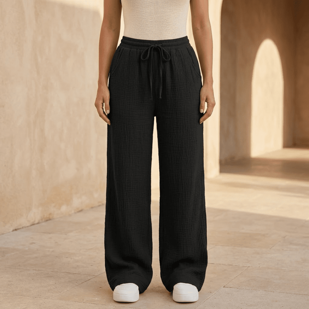 Women's cotton wide-leg trousers by Tammy Bradley, featuring a relaxed fit and high waist, shown in a stylish casual setting.