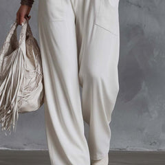 White faux suede western fringe v-neck jumpsuit for women featuring fringe details and a stylish V-neck design.