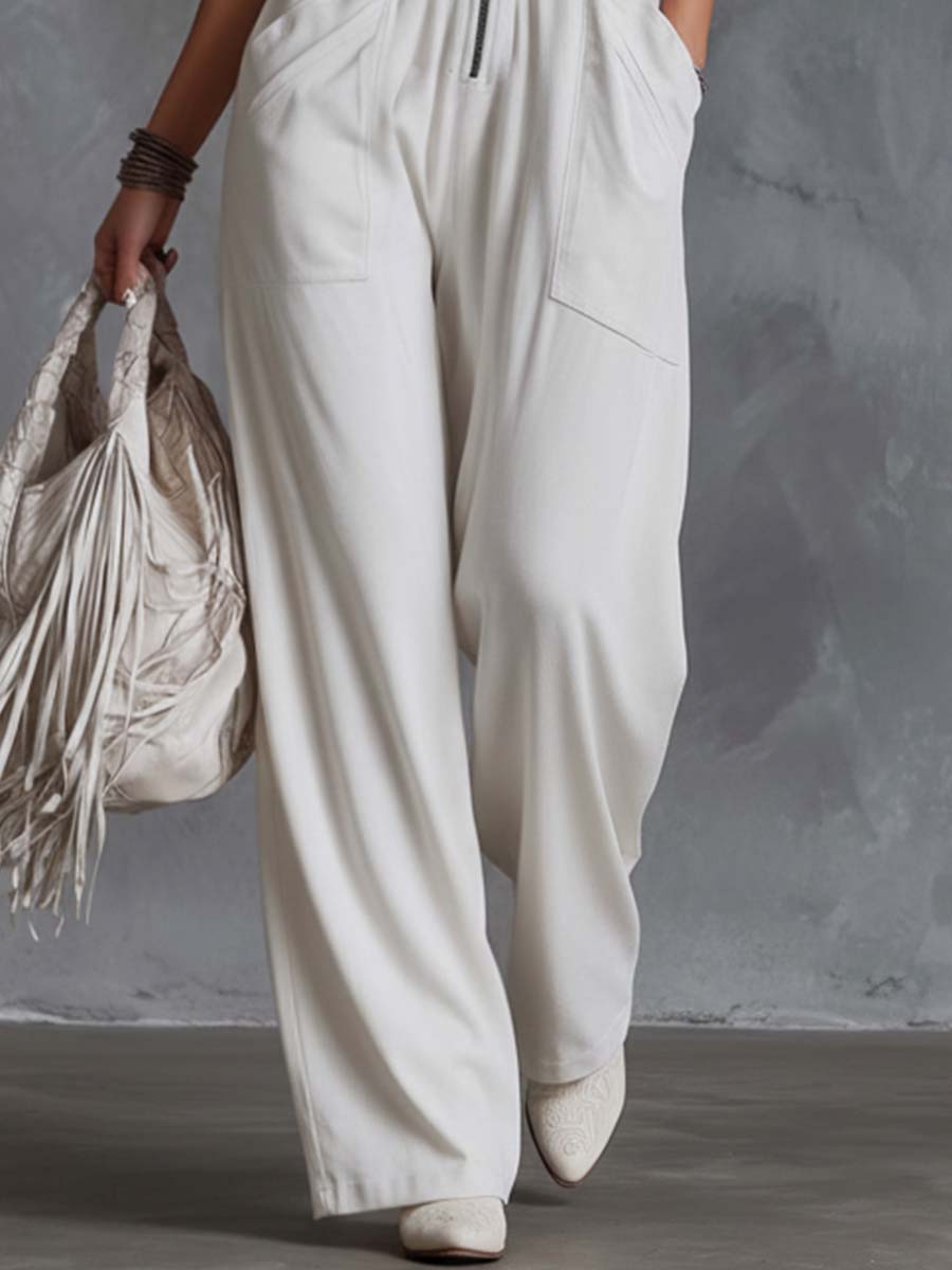 White faux suede western fringe v-neck jumpsuit for women featuring fringe details and a stylish V-neck design.
