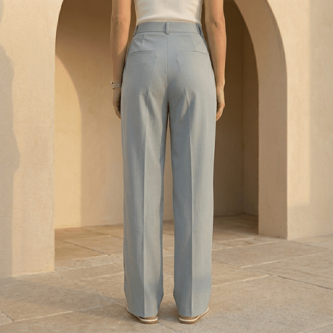 White high-waisted pleated wide-leg women's trousers by Tammy Bradley, showing the flowy, tailored fabric and wide-leg design.