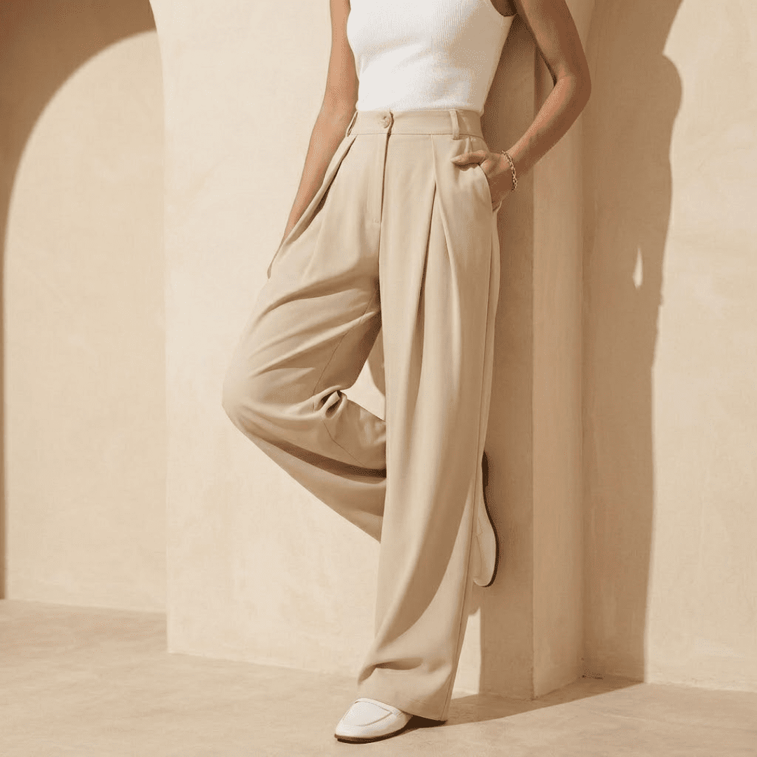 Women's high-waisted wide-leg tailored trousers by Tammy Bradley, shown in a neutral fabric with a waistband and wide-leg silhouette.