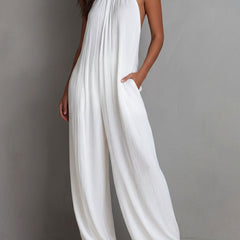 White pleated halter neck wide-leg resort jumpsuit for women, featuring stylish pants with a flowy, comfortable fit.
