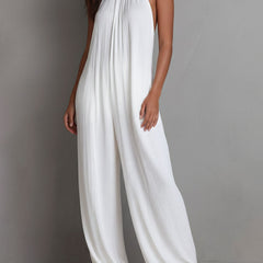 White pleated halter neck wide-leg resort jumpsuit for women, featuring stylish pleats and a halter neckline.