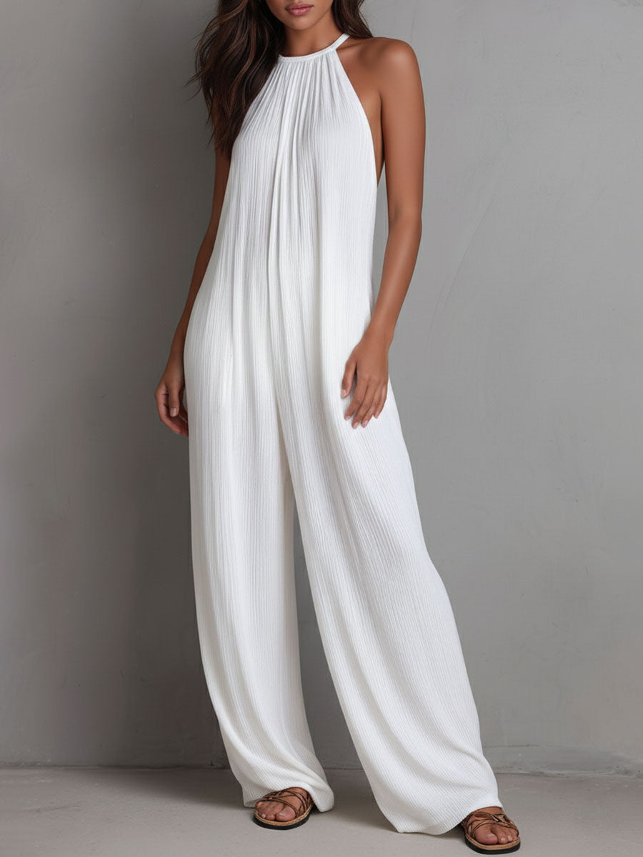 White pleated halter neck wide-leg resort jumpsuit for women, featuring stylish pleats and a halter neckline.