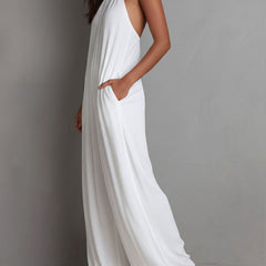 White pleated halter neck wide-leg resort jumpsuit for women, featuring flowy fabric and stylish design.