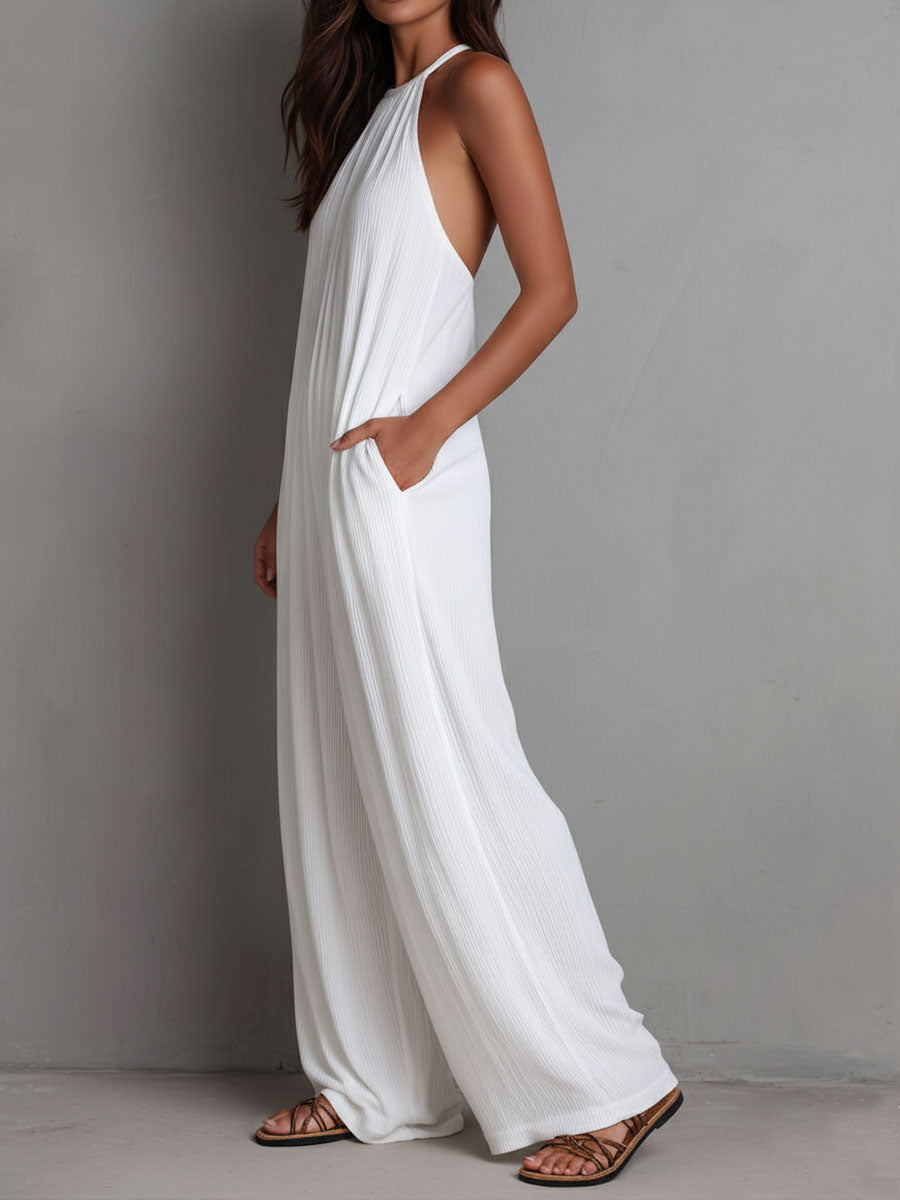 White pleated halter neck wide-leg resort jumpsuit for women, featuring flowy fabric and stylish design.