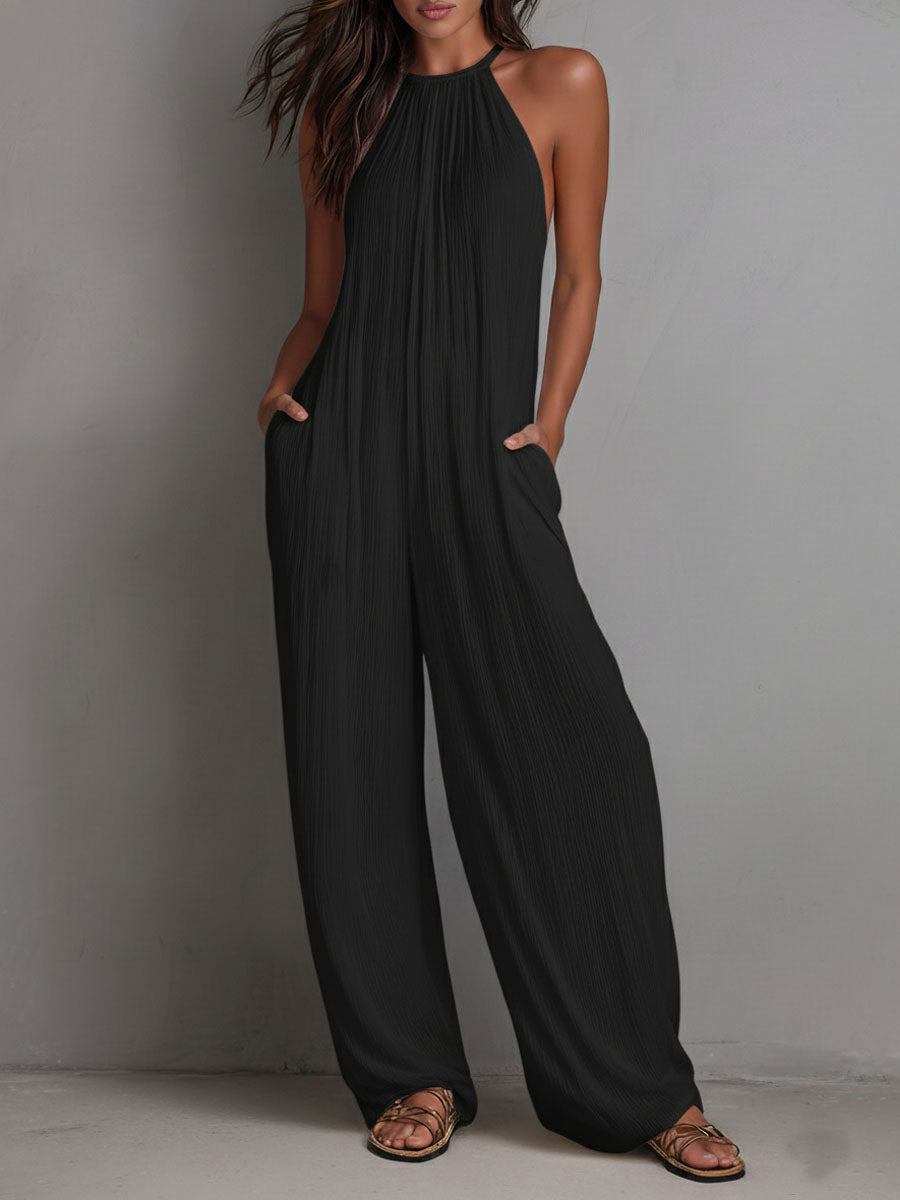 White pleated halter neck wide-leg resort jumpsuit for women, featuring stylish pants and a relaxed fit.