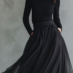 Elegant black tulle flowing maxi dress with patchwork design and fitted knit bodice, showcased on a model.