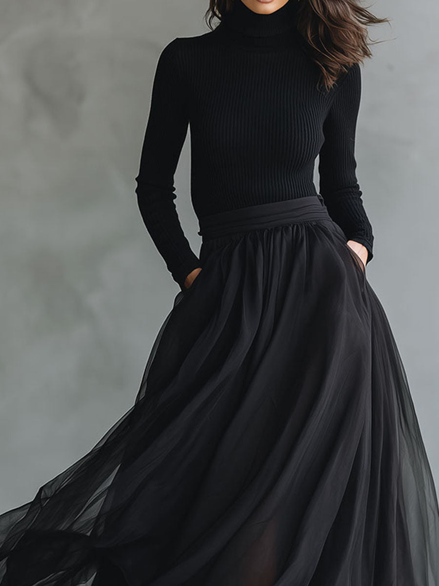 Elegant black tulle flowing maxi dress with patchwork design and fitted knit bodice, showcased on a model.