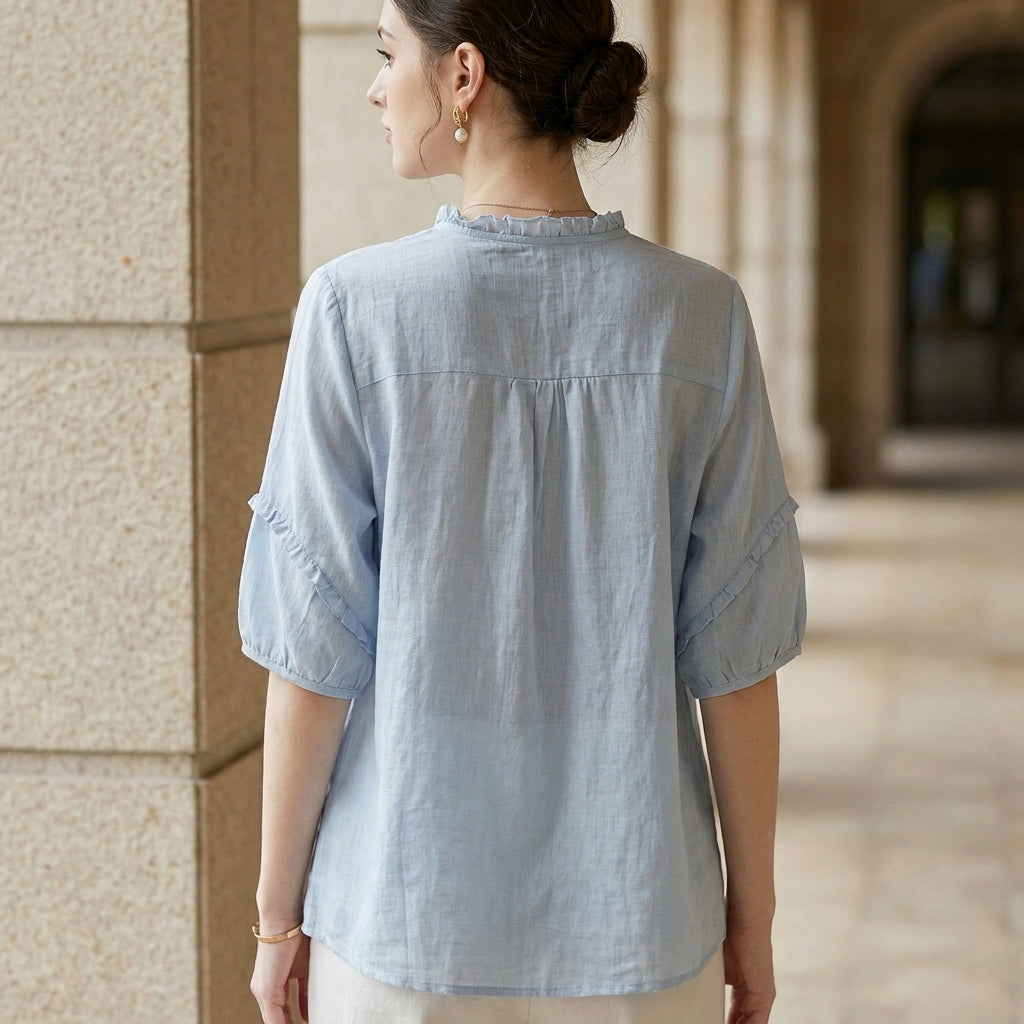 Linen summer blouse for women with ruffle details, shown from the back, stylish and lightweight top ideal for warm weather.