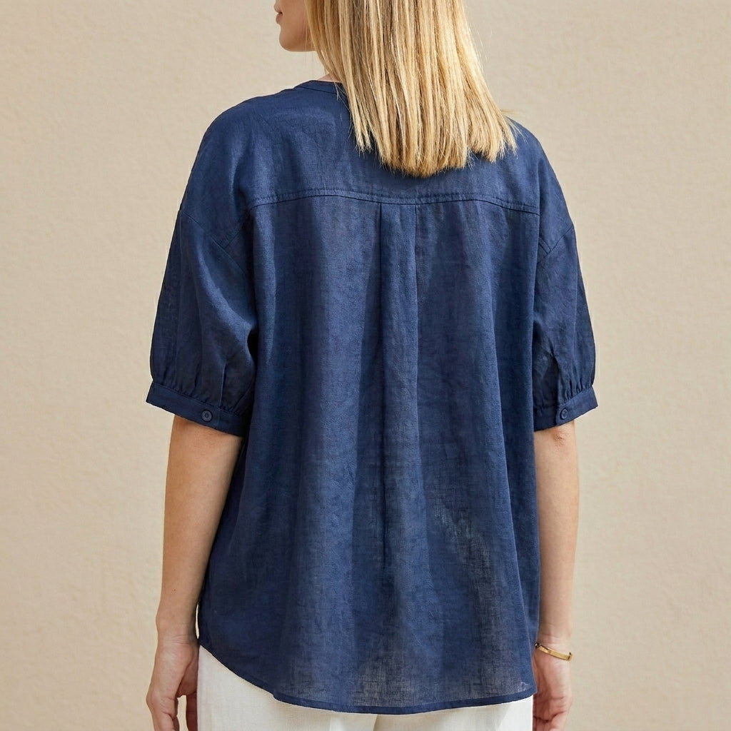 Back view of a women's summer blouse with V-neck and puff sleeves, featuring soft fabric and stylish design.