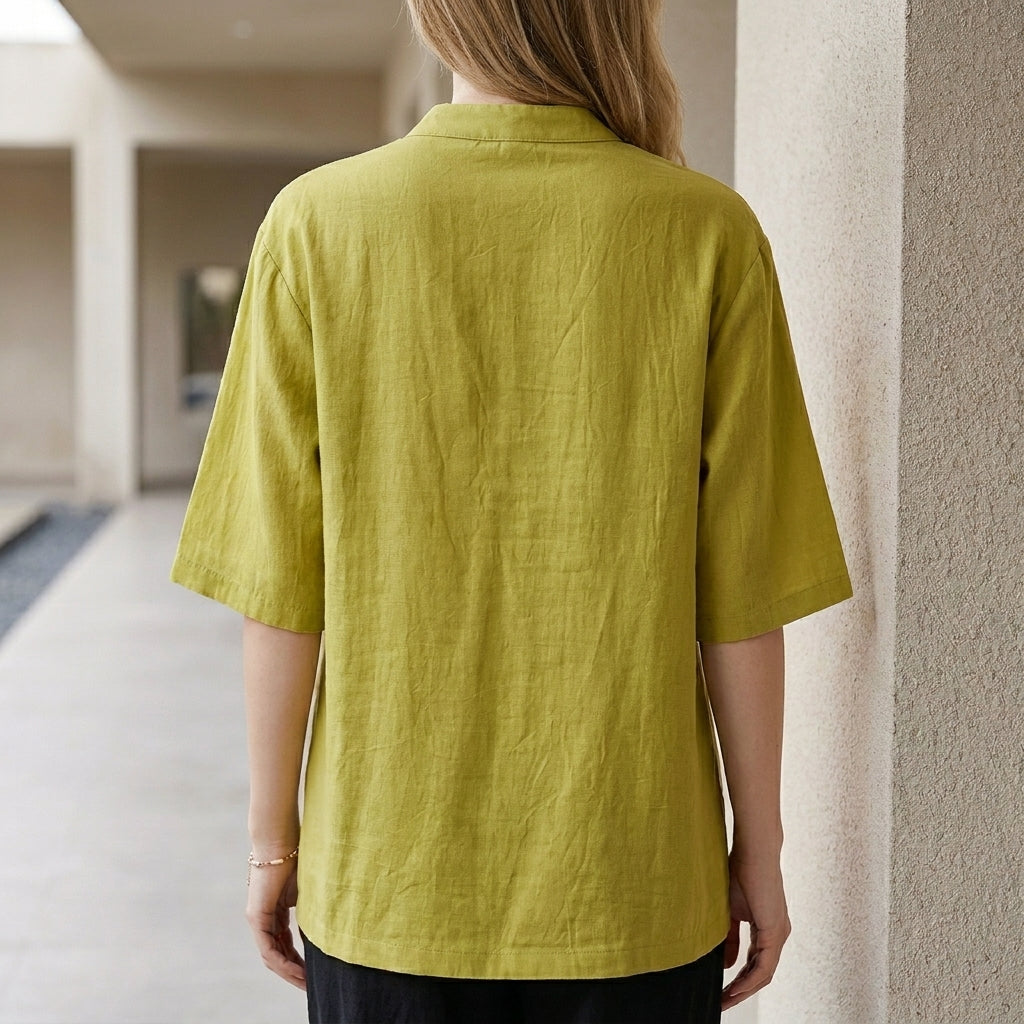 Back view of a women's denim summer blouse with chest pockets, featuring a relaxed fit and casual style.