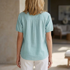 Lightweight denim summer blouse for women with puff sleeves and button front, shown from the back.