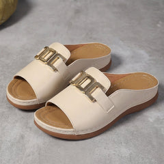 Beige orthopedic slide sandals with buckle detail and contrast stitching, comfortable and supportive footwear for casual wear.