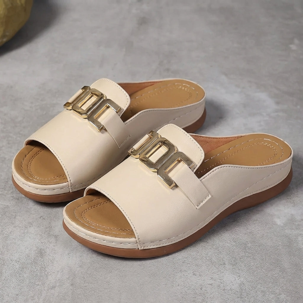 Beige orthopedic slide sandals with buckle detail and contrast stitching, comfortable and supportive footwear for casual wear.