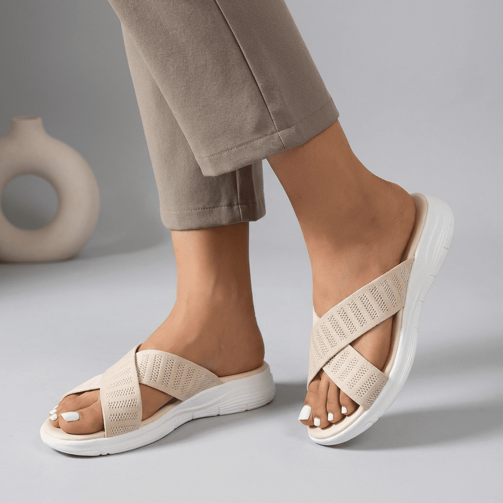 Beige women's criss-cross knit slide sandals by Tammy Bradley showing the stylish open-toe design and comfortable slip-on style.