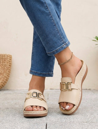 Beige orthopedic slide sandals with buckle detail and contrast stitching, featuring supportive design and casual comfort.