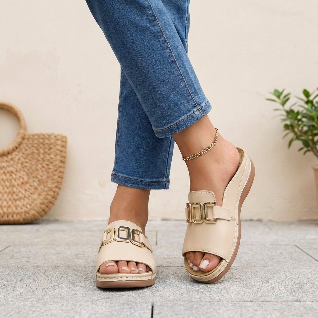 Beige orthopedic slide sandals with buckle detail and contrast stitching, featuring supportive design and casual comfort.