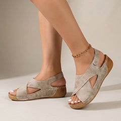 Beige orthopedic criss-cross slingback wedge sandals for women with supportive straps and chunky heels.