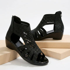 Black women's orthopedic heeled sandals with wedge heel and cut-out design, stylish and supportive footwear.