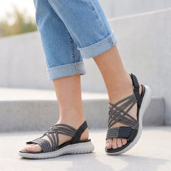 Black orthopedic criss-cross strappy women's sandals with adjustable straps and cushioned footbed for comfort.