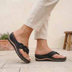 Black floral appliqué wedge thong sandals for women by Tammy Bradley, featuring decorative flower details and comfortable slip-on design.
