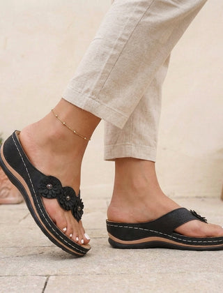 Black floral appliqué wedge thong sandals for women by Tammy Bradley, featuring decorative flower details and comfortable slip-on design.