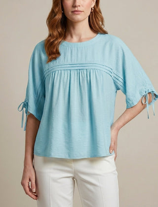 Blue linen summer blouse for women, flowy and lightweight, styled with short sleeves and a relaxed fit.