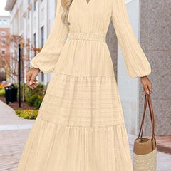 White V-neck pleated waist tiered long-sleeved dress, stylish and flowy, with a flattering fit and elegant design.