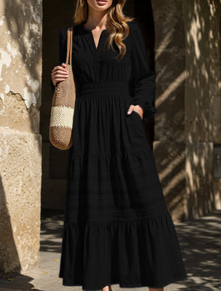 Black V-neck pleated waist tiered long-sleeved dress with a flowing silhouette, featuring a stylish design suitable for various occasions.