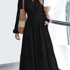 Black V-neck pleated waist tiered long-sleeved dress, stylish and elegant, featuring a flattering silhouette and flowing fabric.