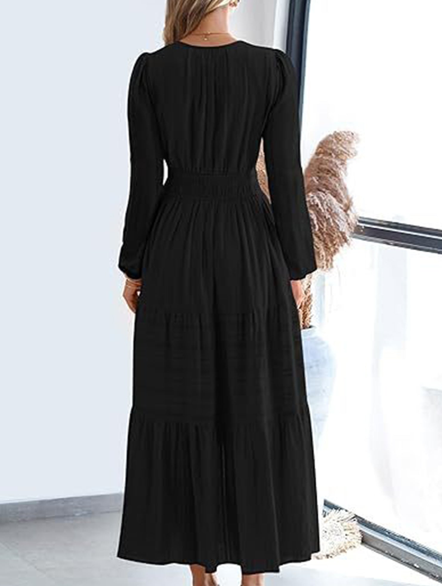 Black V-neck pleated waist tiered long-sleeved dress with a flowing design, featuring a stylish tiered skirt and elegant long sleeves.