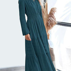 White V-neck pleated waist tiered long-sleeved dress with a flowing skirt and elegant design, perfect for formal or casual occasions.