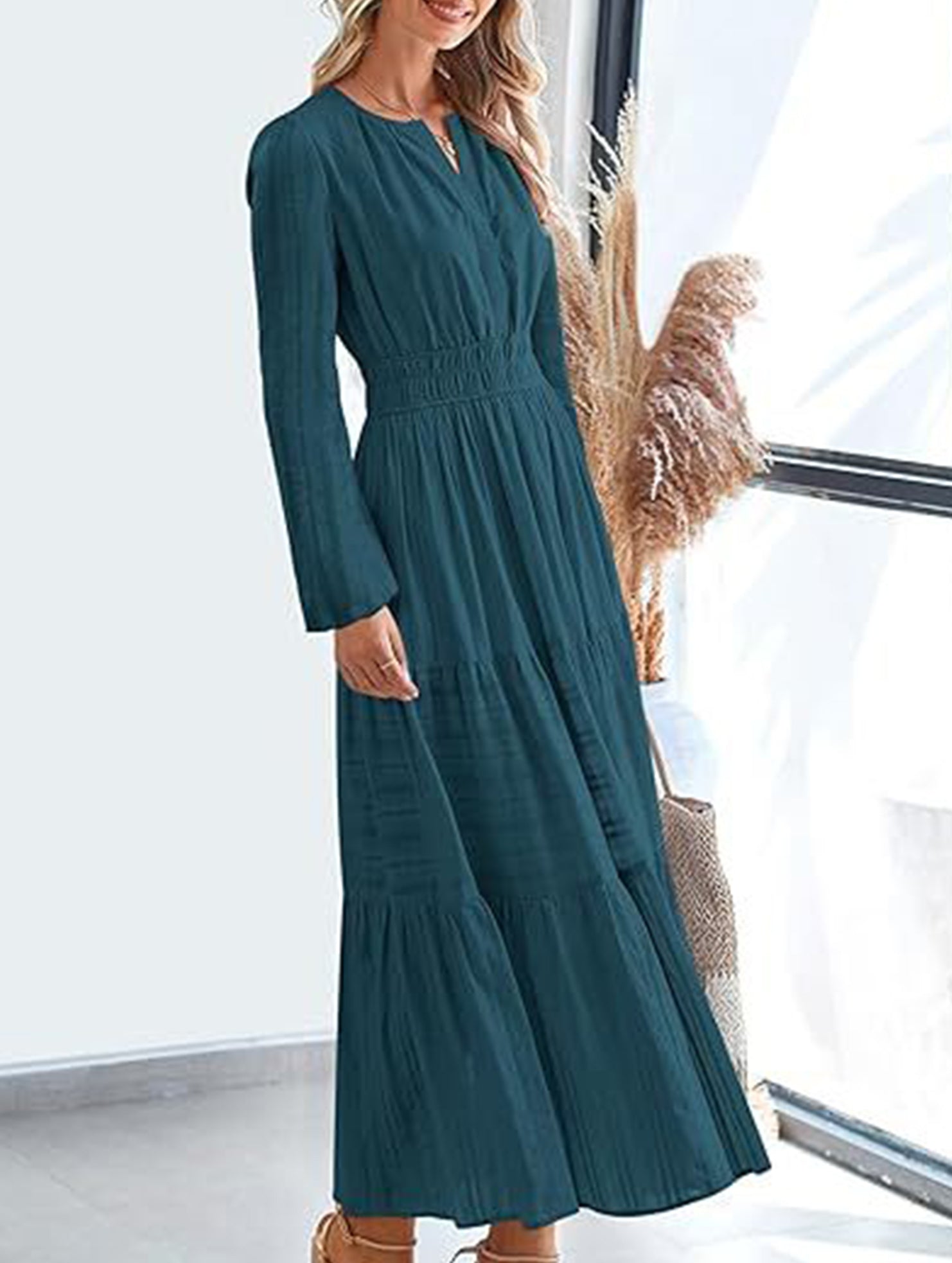 White V-neck pleated waist tiered long-sleeved dress with a flowing skirt and elegant design, perfect for formal or casual occasions.