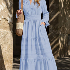 Light blue V-neck pleated waist tiered long-sleeved dress with flowing fabric and tiered hem, stylish and elegant for various occasions.