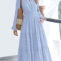 Light blue V-neck pleated waist tiered long-sleeved dress with flowing fabric and elegant design, perfect for casual or formal occasions.