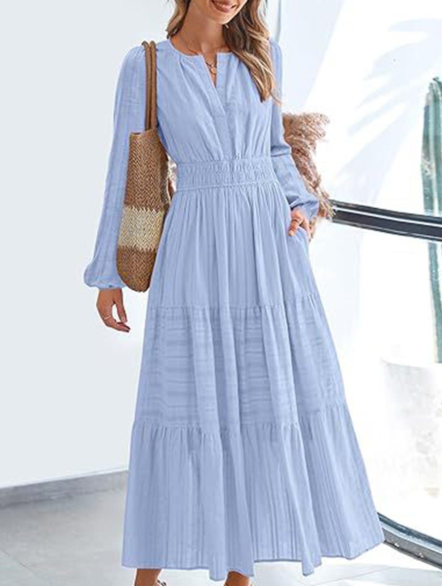 Light blue V-neck pleated waist tiered long-sleeved dress with flowing fabric and elegant design, perfect for casual or formal occasions.